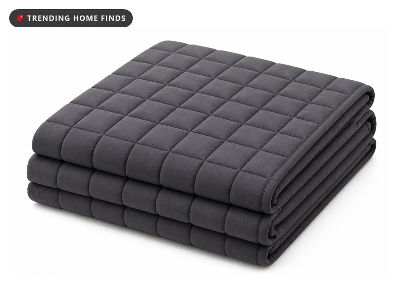 A dark gray quilted weighted blanket folded into a stack, showing a fine grid of small square compartments.