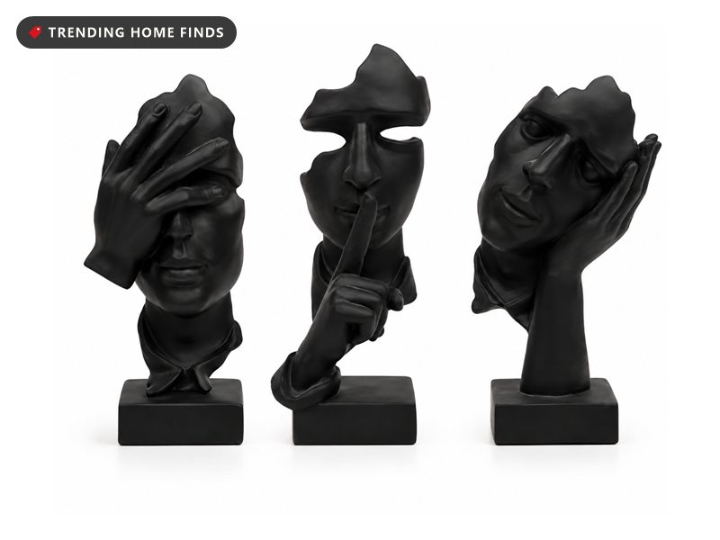 Three black abstract face sculptures with expressive hand poses