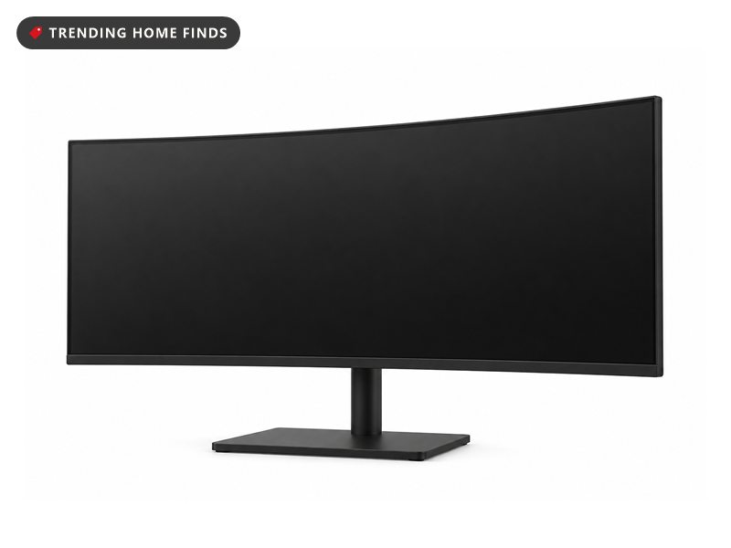 A wide curved ultrawide monitor on a tidy desk in cool pre-dawn light, one keyboard and mouse in front of it and no second screen.