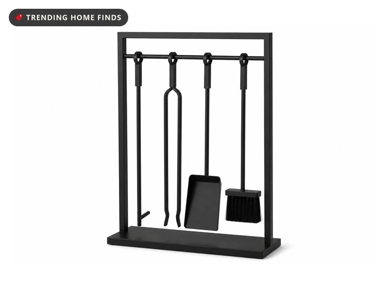 A matte black wrought iron fireplace tool stand holding a poker, tongs, a shovel and a brush.