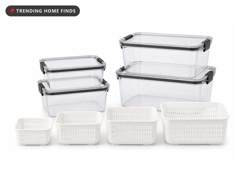 Clear rectangular produce storage boxes with black clip lids, stacked, with white perforated colander baskets in front.