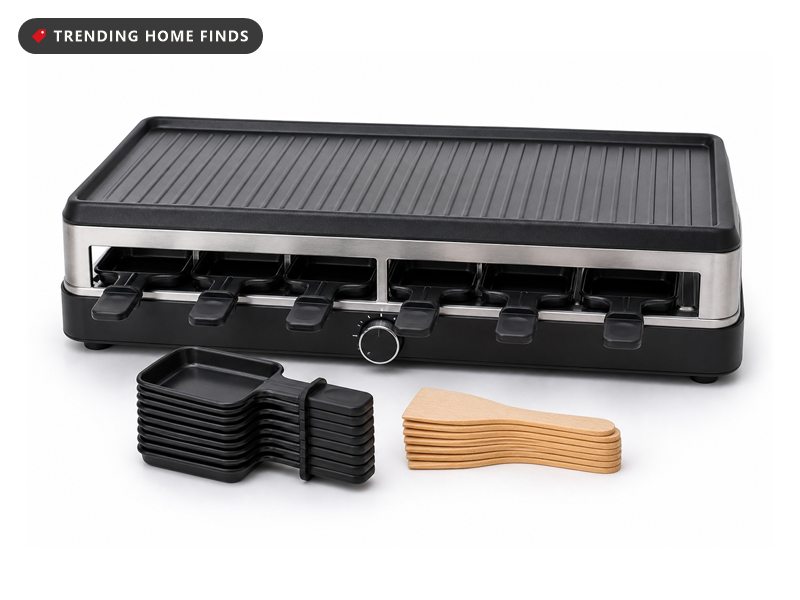 Black raclette table grill with a reversible top plate and eight mini cheese pans with wooden spatulas