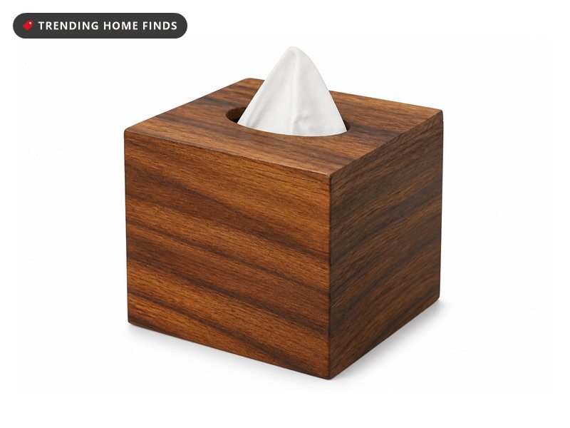 A square acacia wood tissue box cover with mitred corners and a white tissue drawn up through the oval opening in the top.