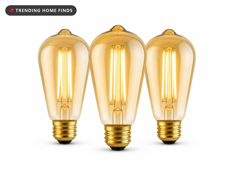 Three amber gilded glass LED Edison bulbs in a round ST64 shape with visible straight filaments.
