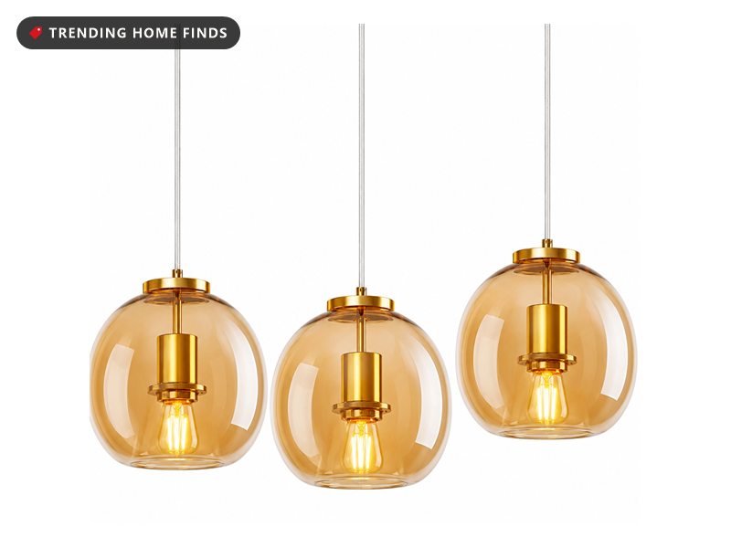 Three amber glass globe pendant lights with gold hardware and visible filament bulbs