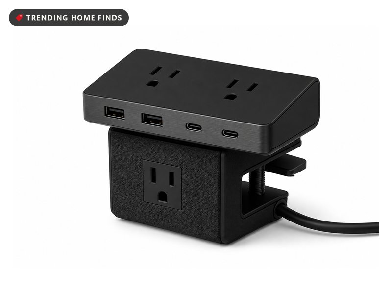 Matte black power strip that clamps over a desk edge, with AC sockets on top and USB ports along the front.