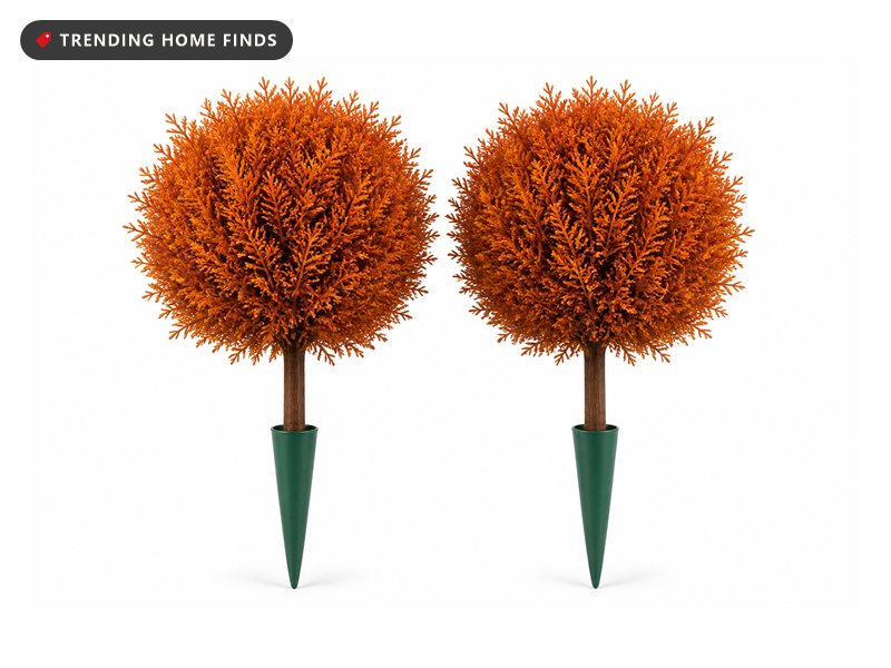 Two round balls of rust orange cedar foliage on short brown trunks seated into tapered dark green ground spikes.