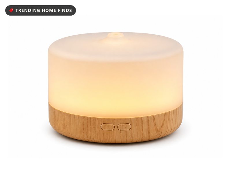 ASAKUKI essential oil diffuser with a wood-grain base and a glowing warm yellow dome releasing mist, shown with its handheld remote control