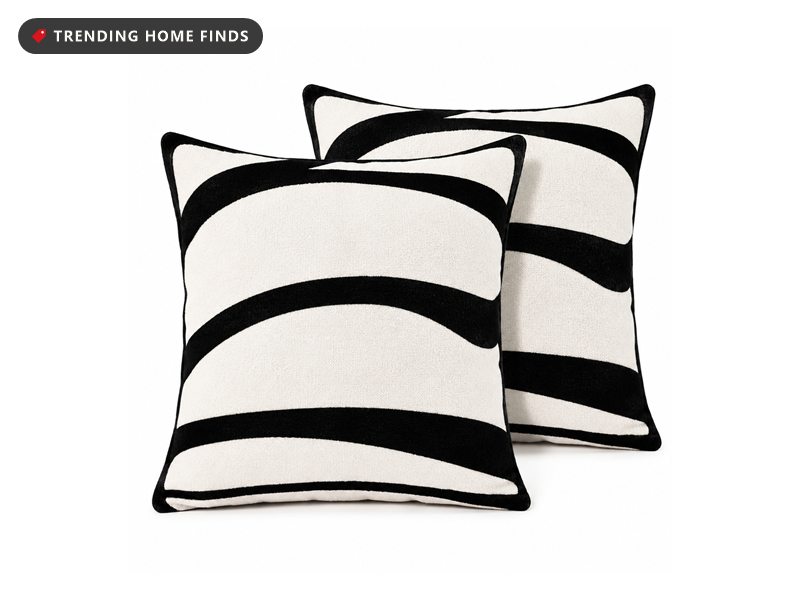 Two white throw pillow covers with bold black curved stripes