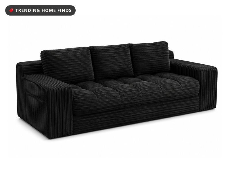 Black corduroy sofa with wide channel cushions and plush armrests