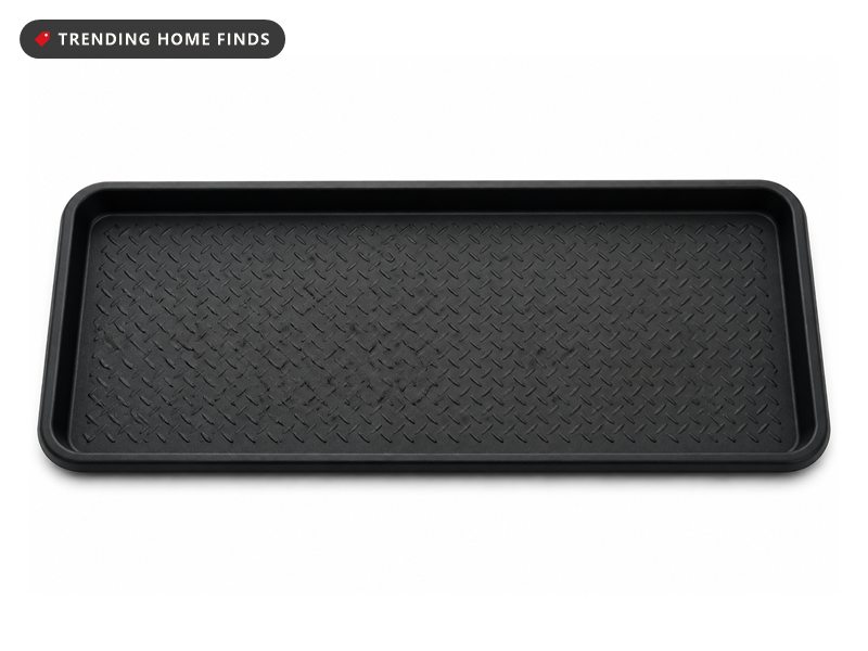 Black rubber boot tray with a raised lip and diamond tread, holding a pair of wet leather boots and a pair of sneakers