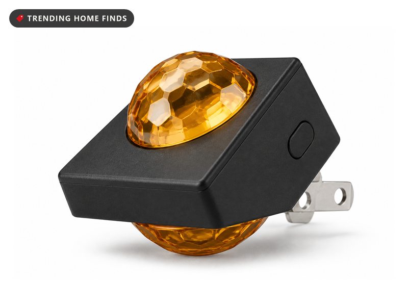 Small black plug-in night light with faceted amber crystal domes on its top and underside.