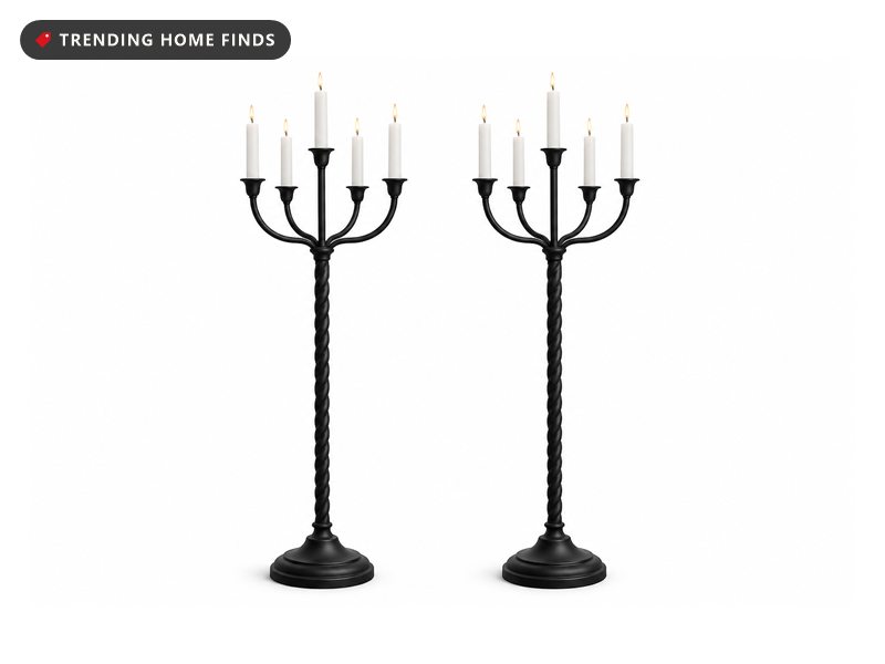 Two matte black five arm floor candelabras with twisted stems and round stepped bases, holding lit white tapers.