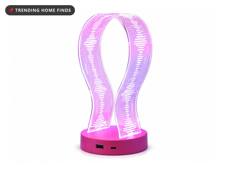 Clear acrylic headphone stand shaped like two curved arms etched with fine lines, lit purple and pink from a round magenta base with a USB-A and a USB-C port on its front