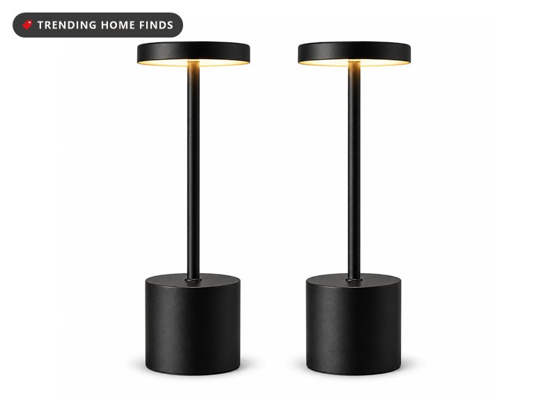 Two black cordless table lamps with slim stems and flat round shades