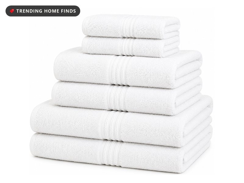 Stack of folded white Turkish cotton towels in bath, hand and washcloth sizes with a ribbed woven border