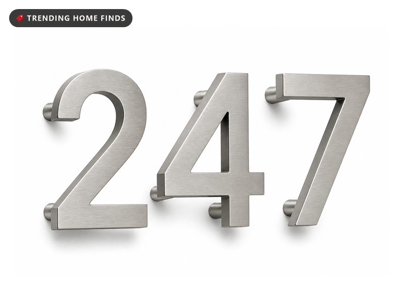 Brushed stainless steel house numerals reading 247 with visible standoff mounting posts behind them.
