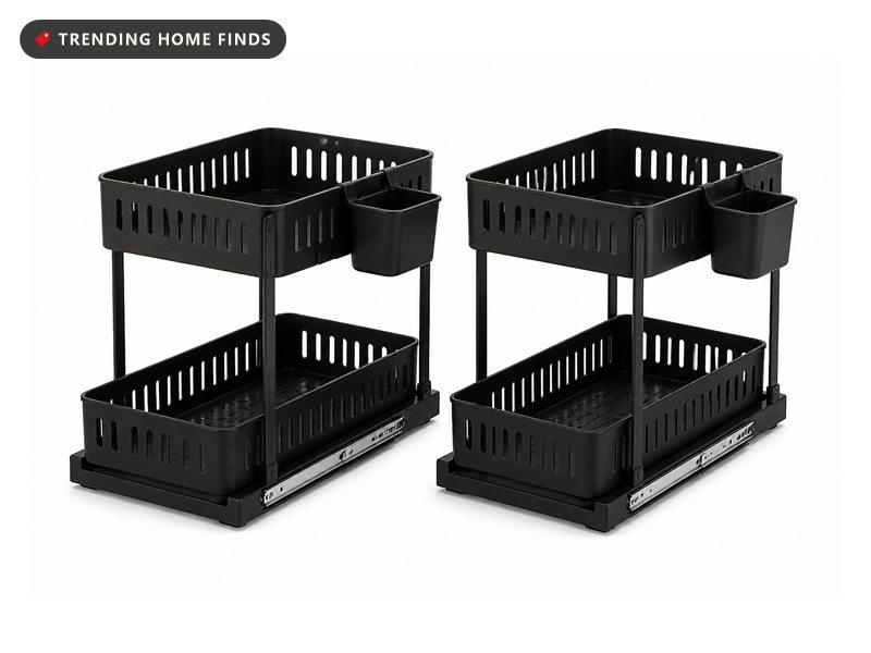 Two black two-tier under-sink organizers with sliding baskets, installed beneath a sink and holding toiletries and cleaning bottles
