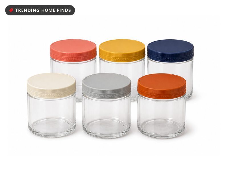 Six clear glass jars with wide screw lids in coral, mustard, navy, cream, grey and burnt orange.