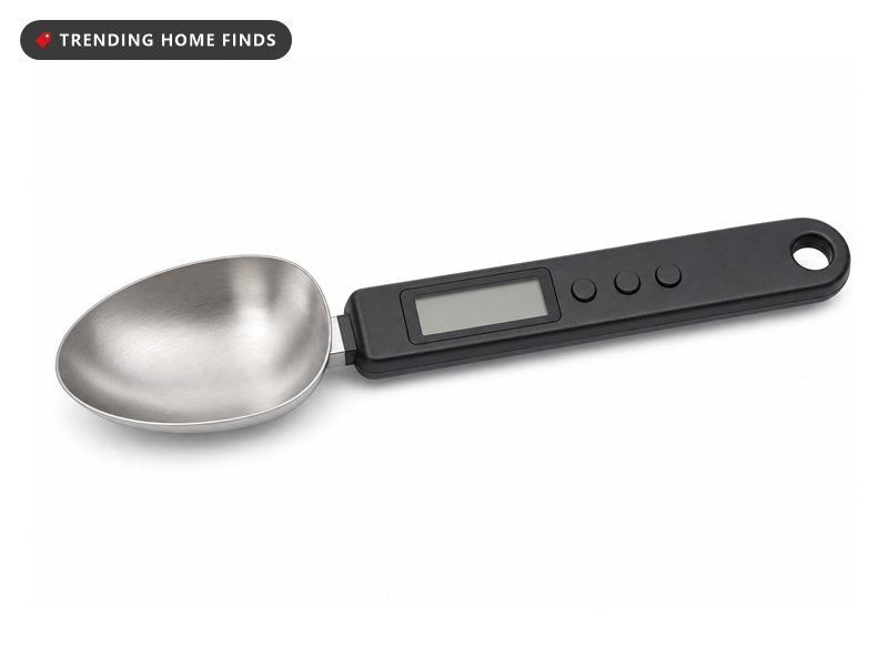 Digital measuring spoon scale with a stainless bowl and lit display, on a white background