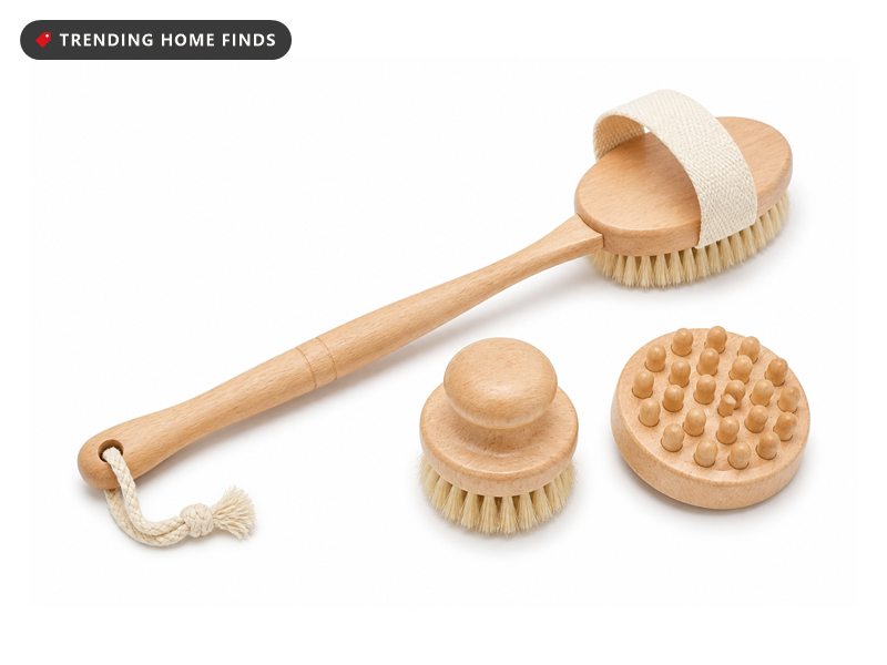 A long handled beech body brush with pale natural bristles beside a small face brush and a nub massage head.