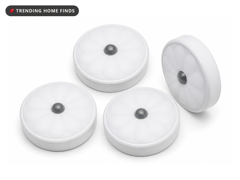 Four round white LED puck lights with scalloped diffuser faces and a small central motion sensor dome.