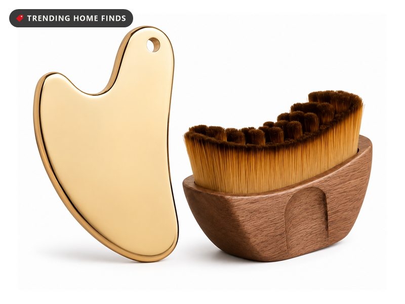 Gold heart-shaped gua sha tool beside a wooden facial brush