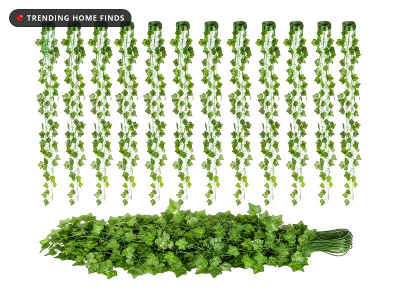 Twelve strands of artificial green ivy vine garland hanging vertically, with a bundled pile of the same leaves below