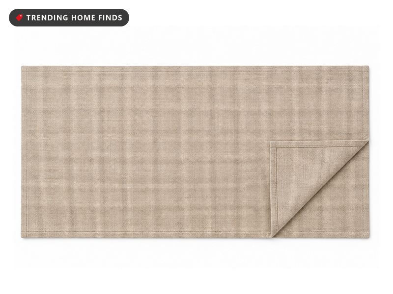 A neutral beige faux linen table runner laid flat with one corner turned back.
