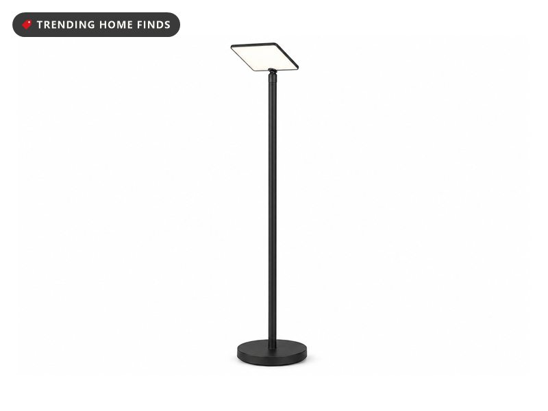 Slim black floor-standing LED torchiere uplighter lamp with a round base, on a white background