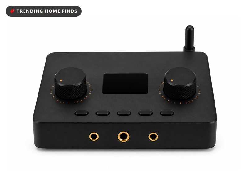 Black aluminum desktop headphone amplifier with two large knurled knobs, a small orange display and gold ringed front jacks.