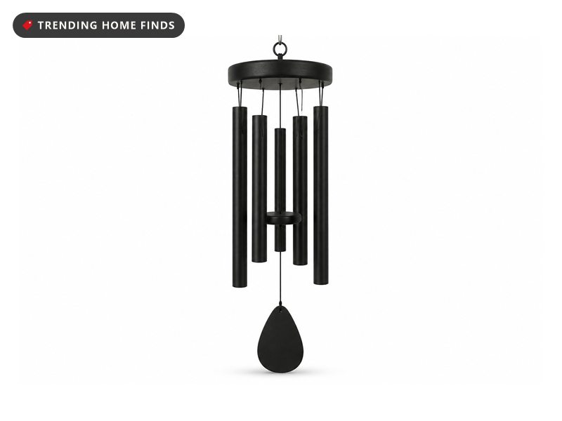 A matte black wind chime with six graduated aluminum tubes, a round top disc and a teardrop wind sail.