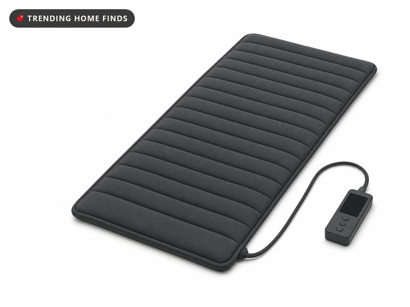 Long grey full body mat rolled out beside its handheld controller, on a white background
