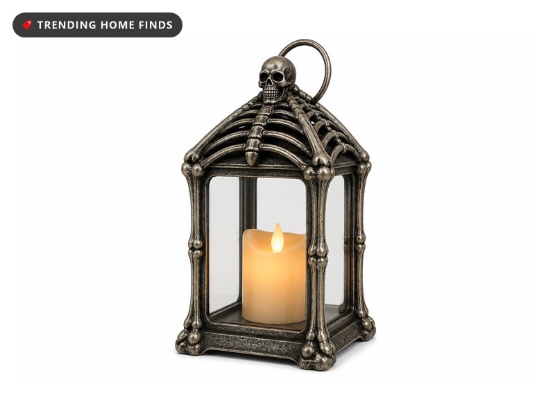 A twelve inch black and silver lantern with bone shaped corner posts, a ribcage roof and a lit flameless candle inside.