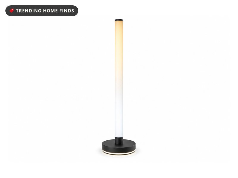Tall slim black corner floor lamp with an illuminated column, on a white background
