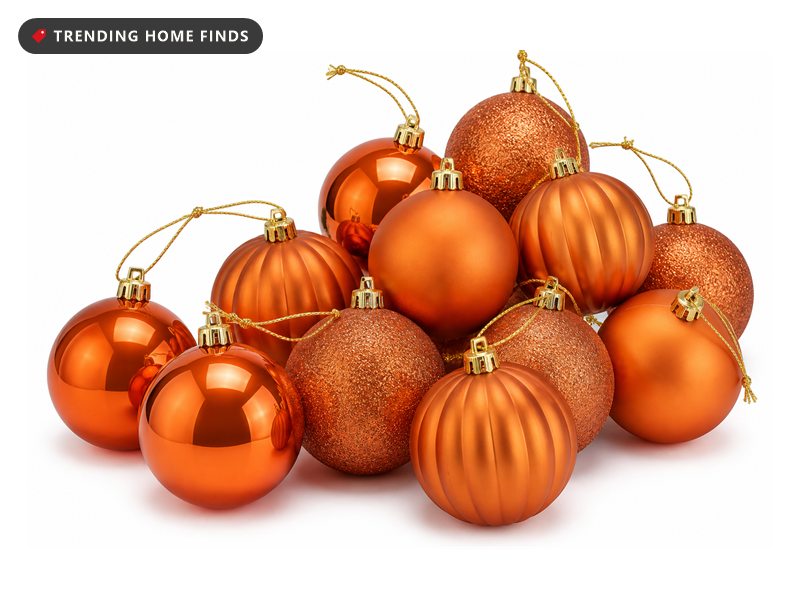 Two dozen orange and copper ball ornaments in gloss, matte, glitter and ribbed pumpkin finishes with gold string hangers.