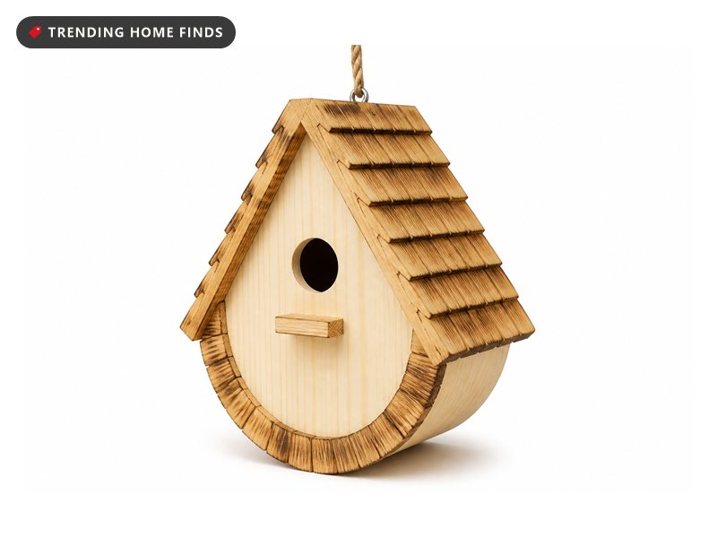 A natural wood birdhouse with a rounded teardrop body, a scorched shingle roof, a round entrance hole and a hemp rope hanger.