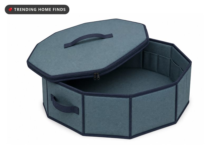 Octagonal teal hard shell wreath storage box with navy trim, dual zippers and webbing carry handles, lid tilted open.