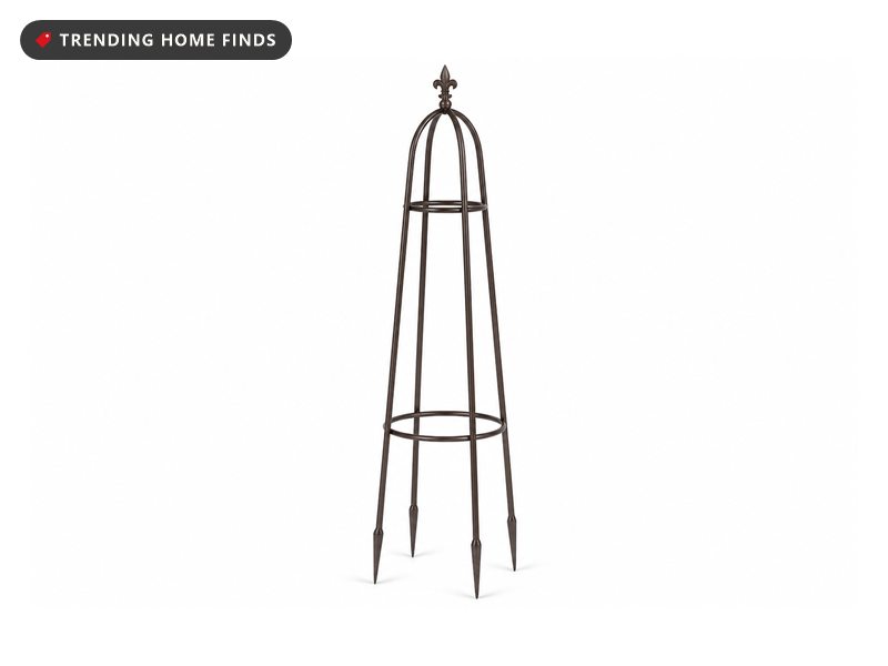 Tall bronze metal garden obelisk with four tapering rods, two ring bands and a pointed finial.