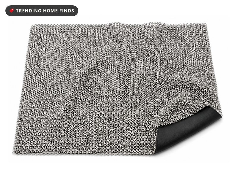 Square sheet of fine stainless steel chainmail rings lying flat, with a matte black silicone pad behind one folded corner.