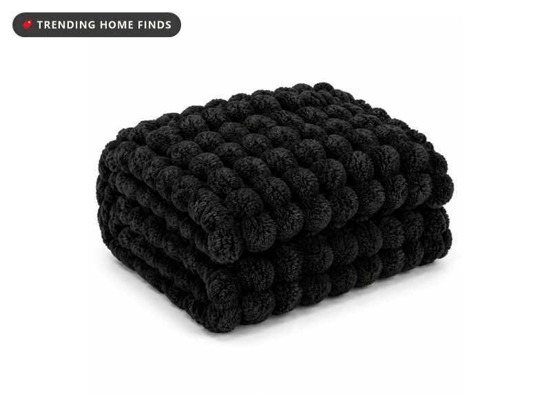 Folded black fleece throw blanket with a raised bubble textured weave