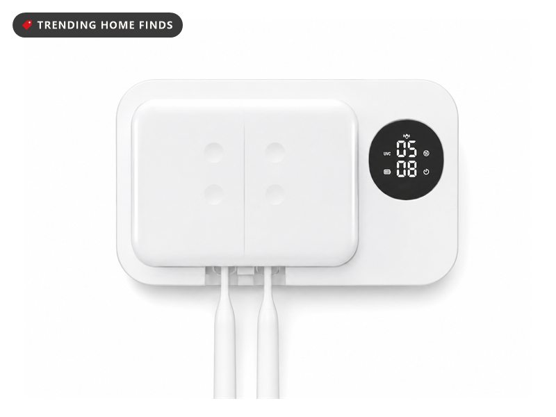 Compact white wall mounted toothbrush sanitizer with a hinged front cover, a small round display and a slot underneath.