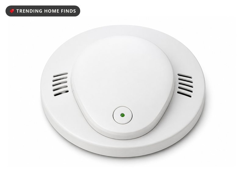 Round white combination smoke and carbon monoxide alarm with a raised oval cover and a green status light.