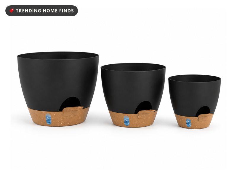 Three black self watering planters in graduated sizes with speckled tan bases and small blue water level windows, on a white background