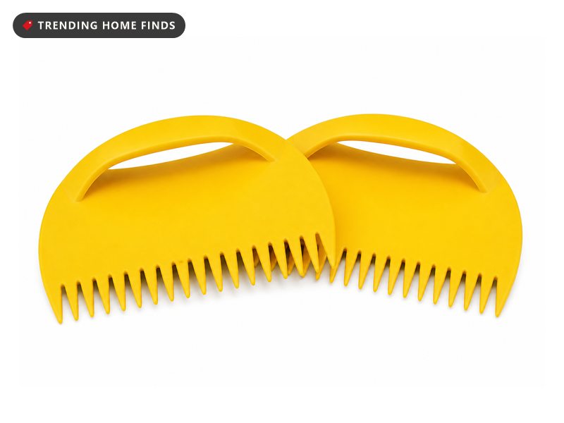 A pair of bright yellow plastic leaf scoops, each a broad fan shaped blade with pointed teeth and a strap handle.
