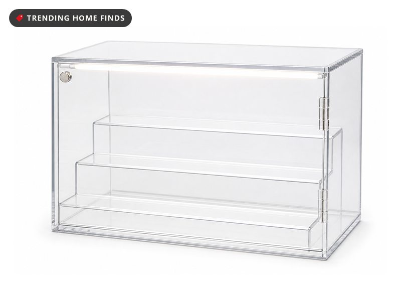 A lit clear acrylic display case with three stepped tiers of small figures and a magnetic front door.