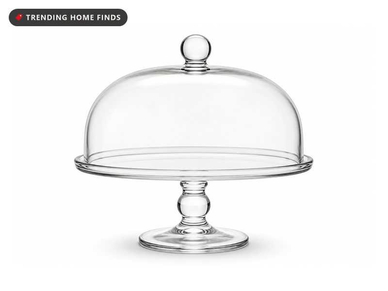 A clear footed glass cake stand with a rolled rim under a curved clear glass dome topped by a round glass ball.