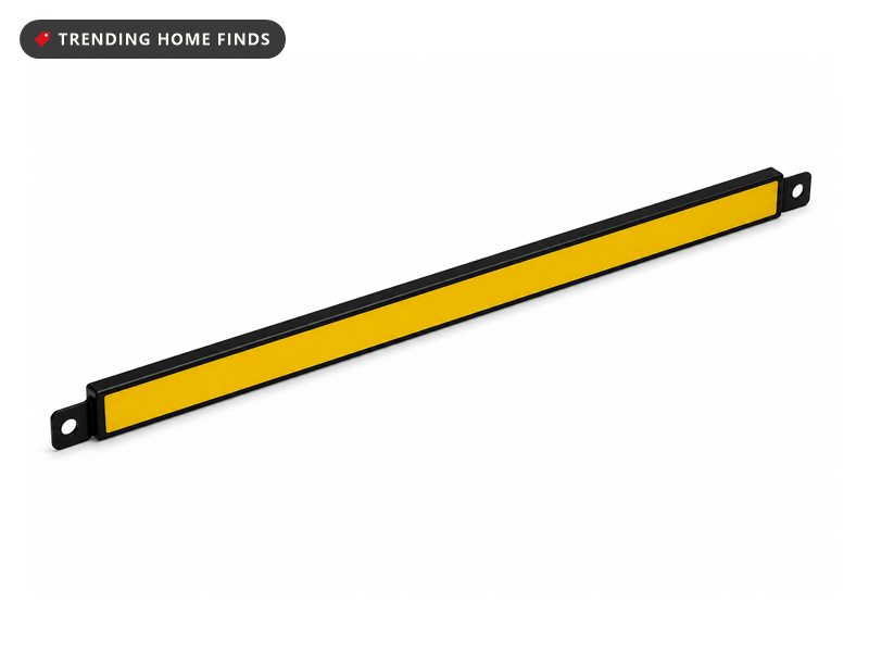 A black magnetic tool bar with a yellow magnetic strip holding wrenches and screwdrivers in a row on a wall.