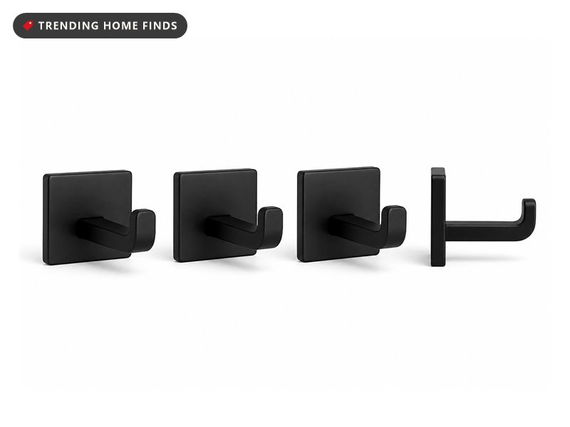 Four matte black wall hooks with small square backplates and rounded arms turning up at the end.
