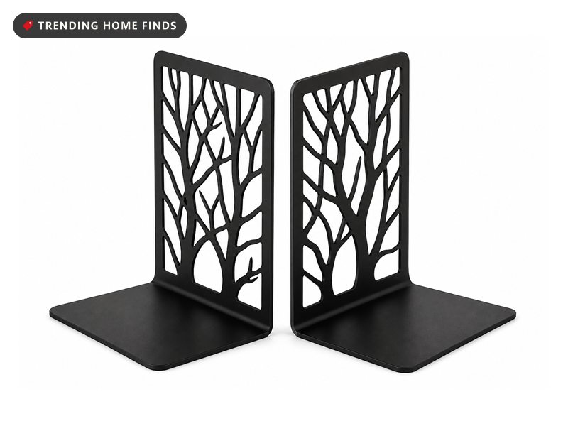 Two matte black steel bookends with laser cut tree branch panels holding a row of books upright.